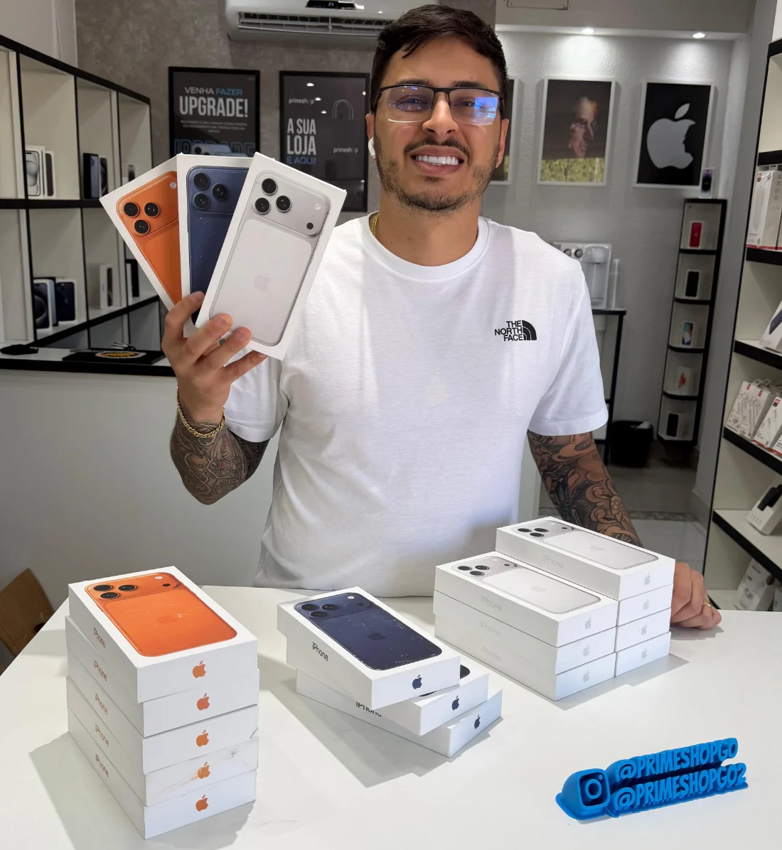 Fundador do Phone Gestão no balcão da Prime Shop, segurando iPhones lacrados